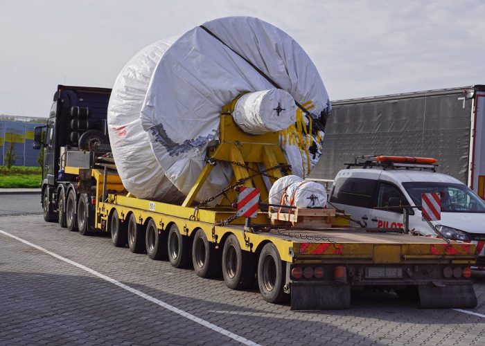 Un camión de grandes dimensiones que transporta un objeto importante en su plataforma, demostrando su capacidad para cargas pesadas.