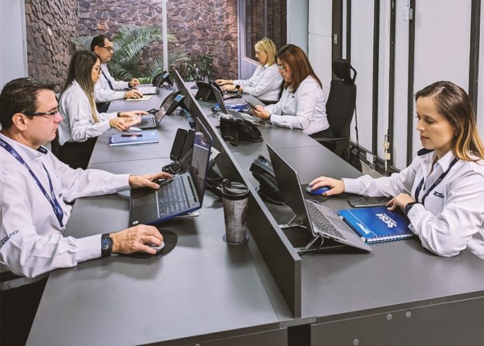 Un grupo diverso de profesionales que colaboran con computadoras portátiles en un entorno de oficina moderno.